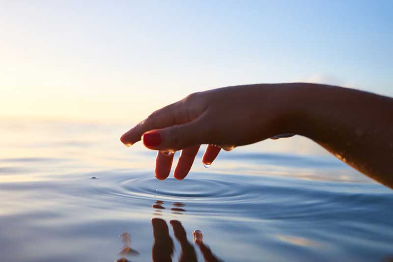 Photo of hand in water.